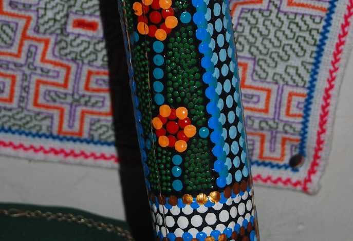Detail of Decoration of a Didgeridoo against an Hallucinogenic Weaving of the Shipibo Indians